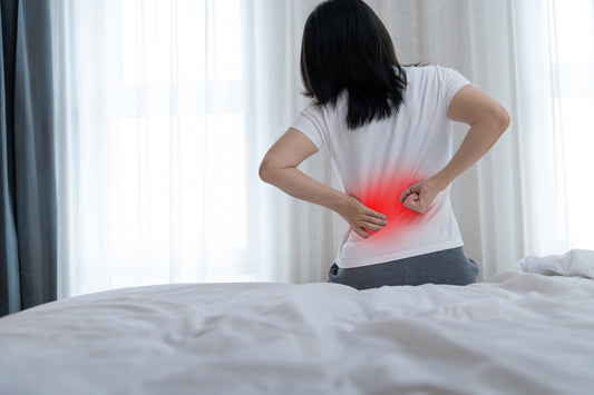 Person experiencing lower back pain illustrating the need for posture correction and back support