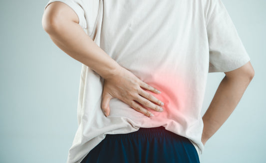 Man pressing his lower back with red inflammation highlight indicating acute lower back pain from herniated disc or muscle strain