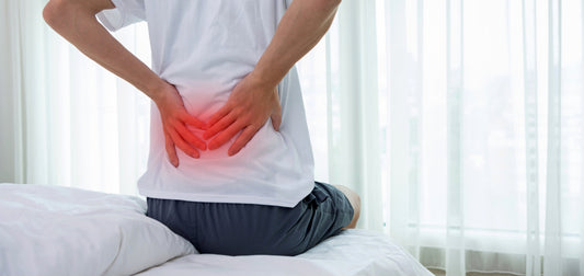 Man holding lower back with red inflammation highlight showing lower back pain and muscle strain