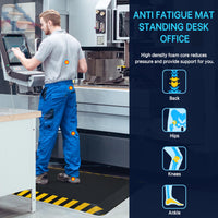 Worker standing on black anti-fatigue mat at industrial workstation, showing pressure relief points on back, hips, knees, and ankles