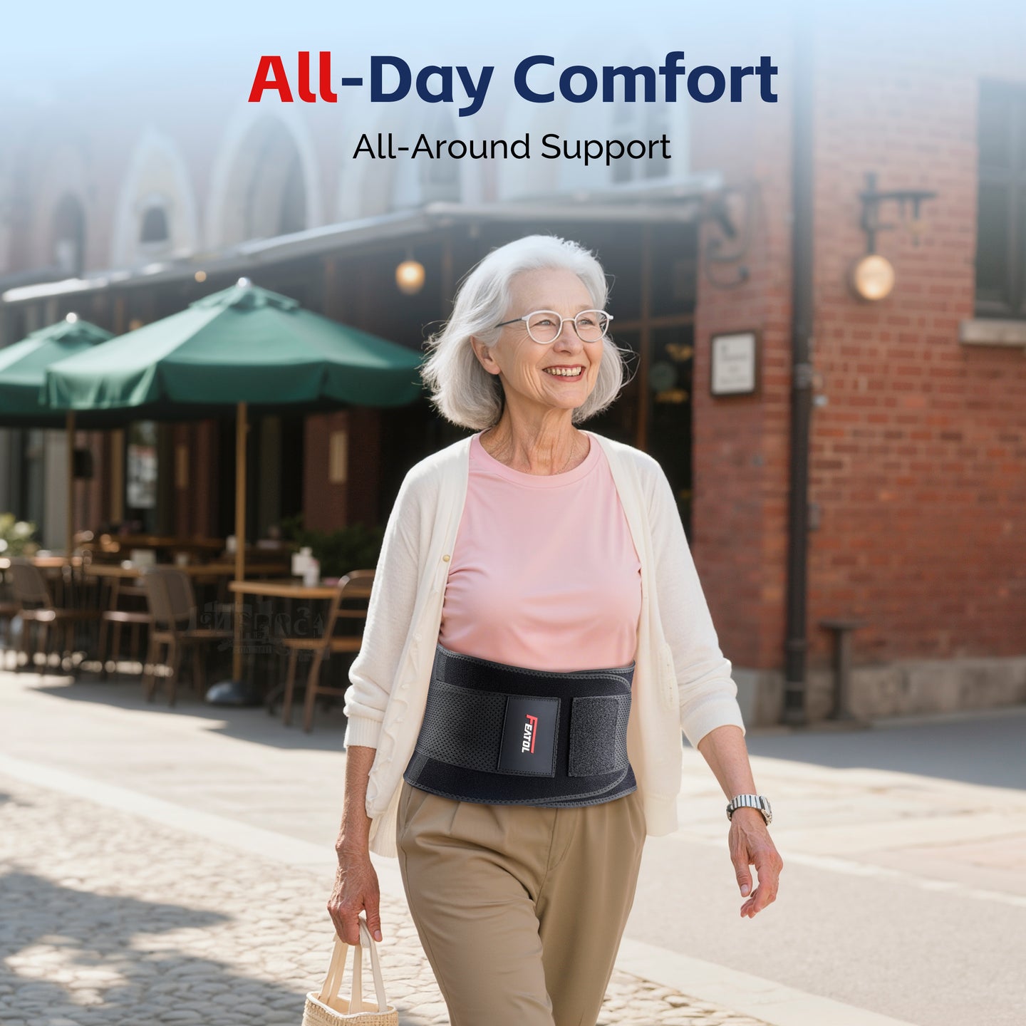 Smiling elderly woman walking outdoors on a sunny street wearing FEATOL back brace under her cardigan, demonstrating all-day comfort and all-around lumbar support for daily activities and pain-free living