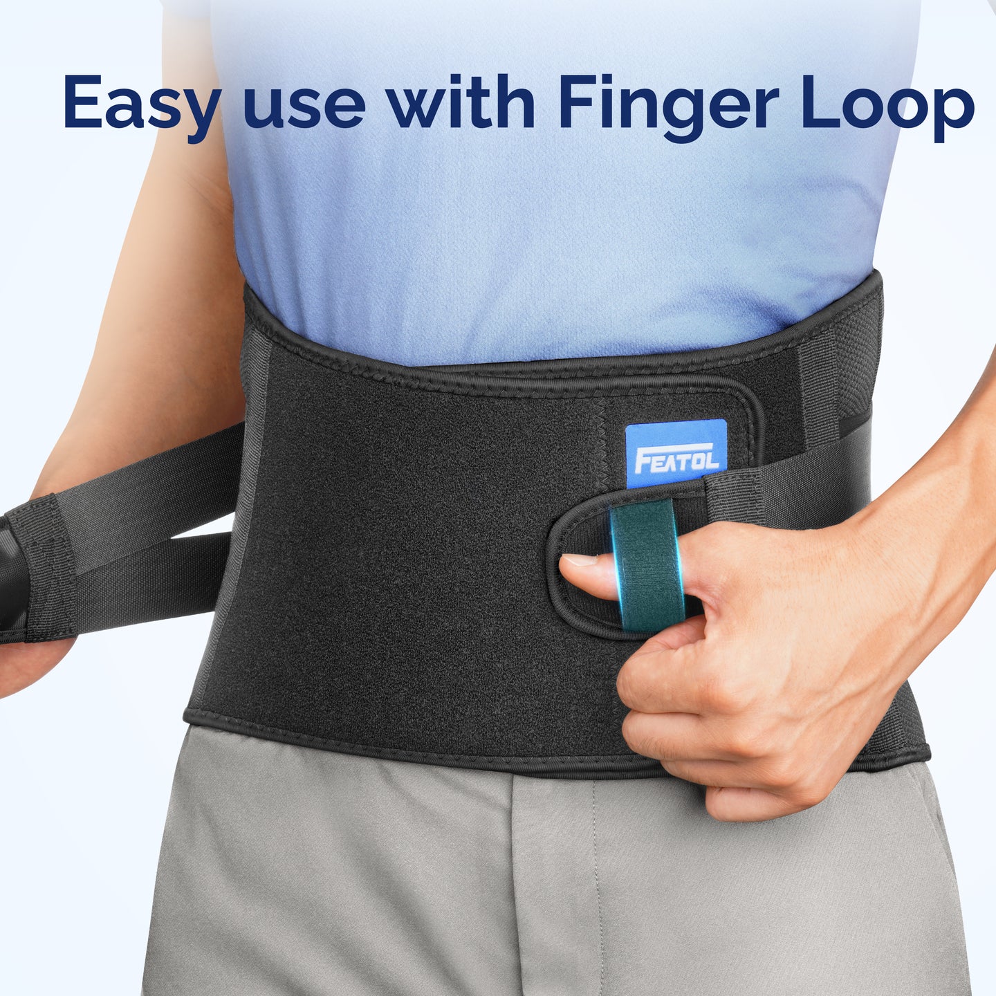 Person pulling on FEATOL back brace using built-in finger loop tab on the front panel, demonstrating easy one-handed application and removal with FEATOL logo label visible