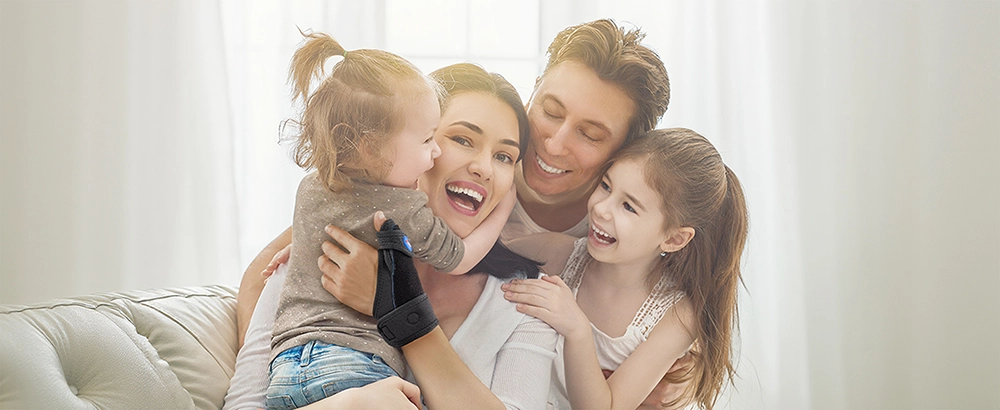 Mother wearing FEATOL thumb brace holding baby